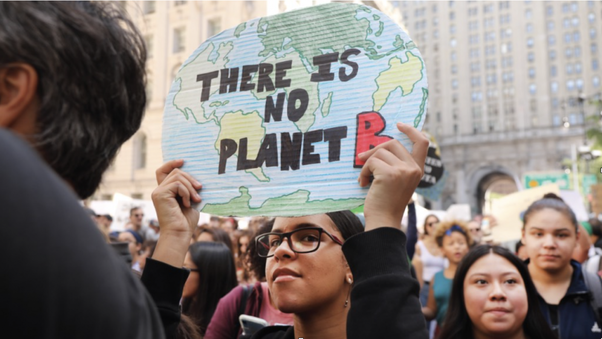 Young woman holds up sign reading "There is no Planet B"