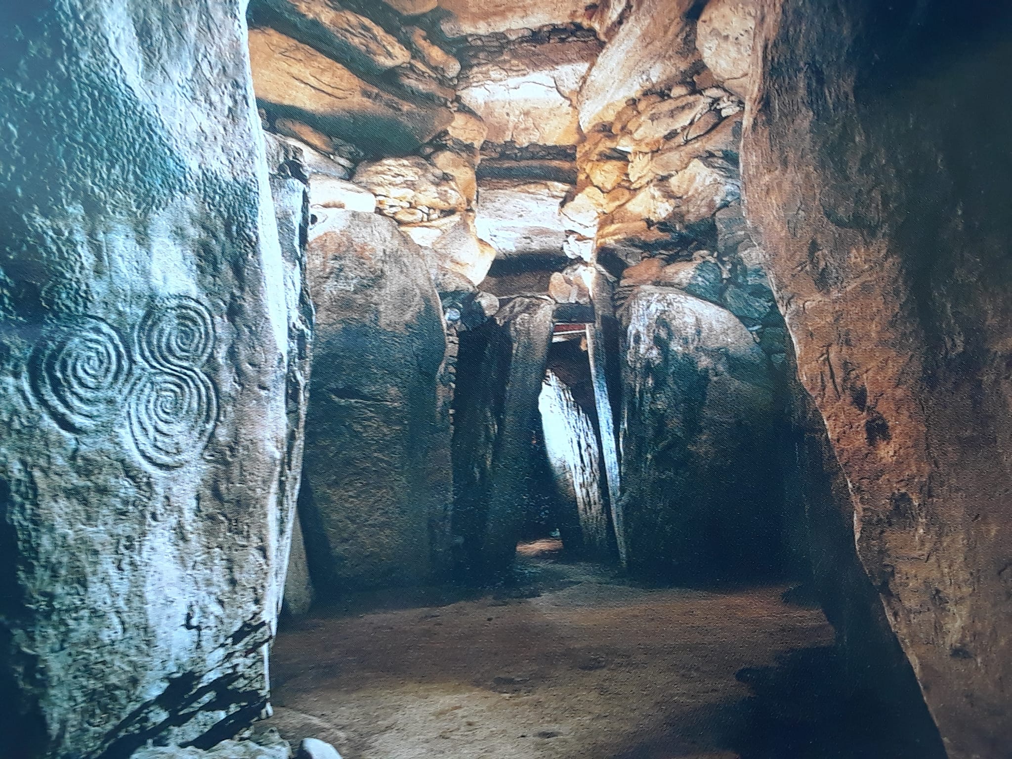 Illuminated cave with spirals carved onto the walls