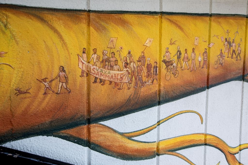 Painted mural that shows yellow root with marchers inside